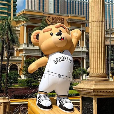 Orso simpatico cartone animato pubblicitario gonfiabile che gioca a basket